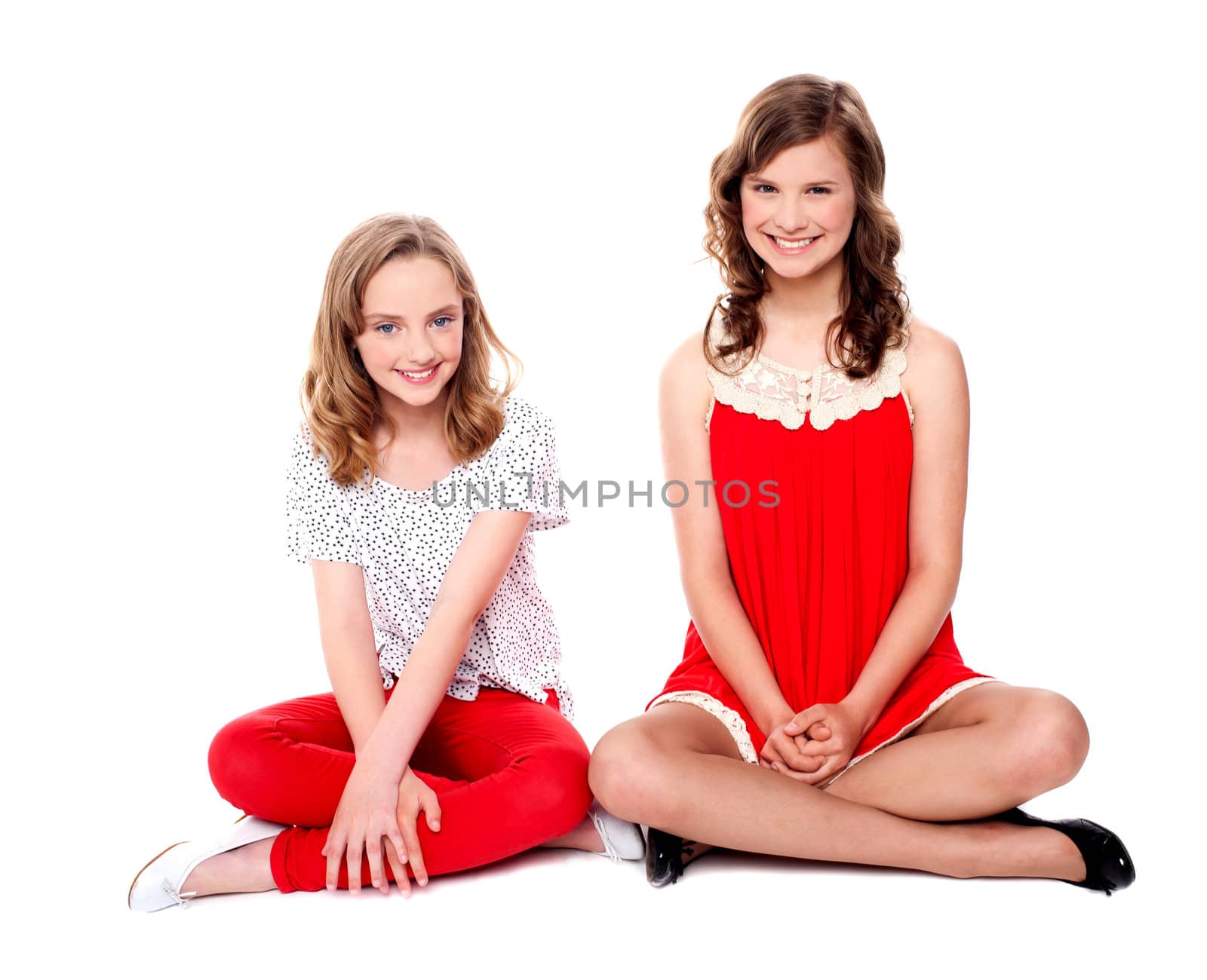 Two glamorous friends sitting together smiling at camera