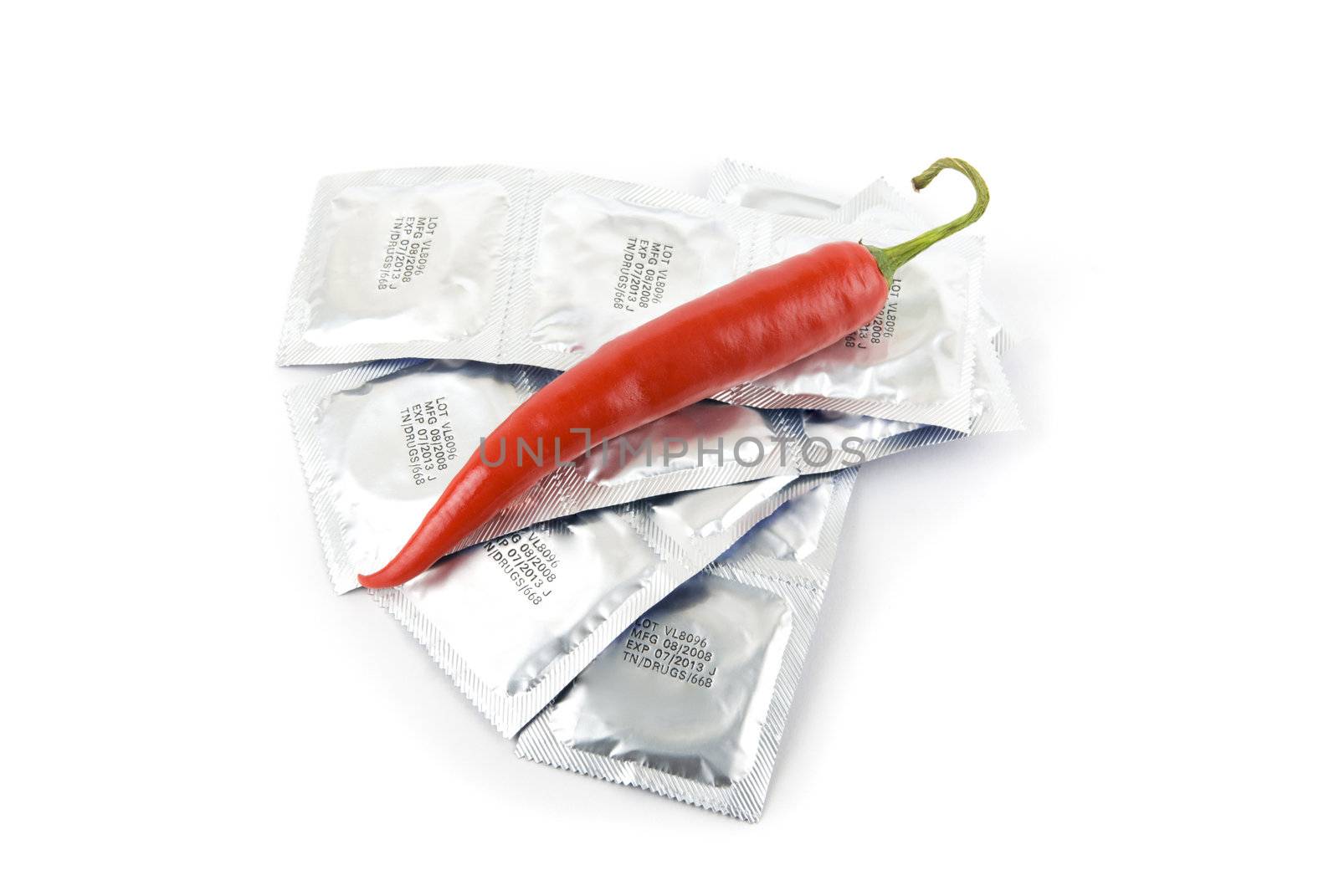 Red peppers on a condom packs over  white background
