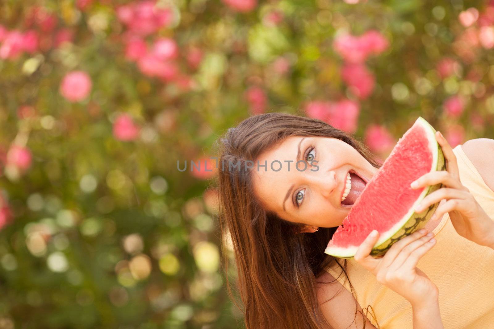 Portrait of a beautiful young woman eating watermelon