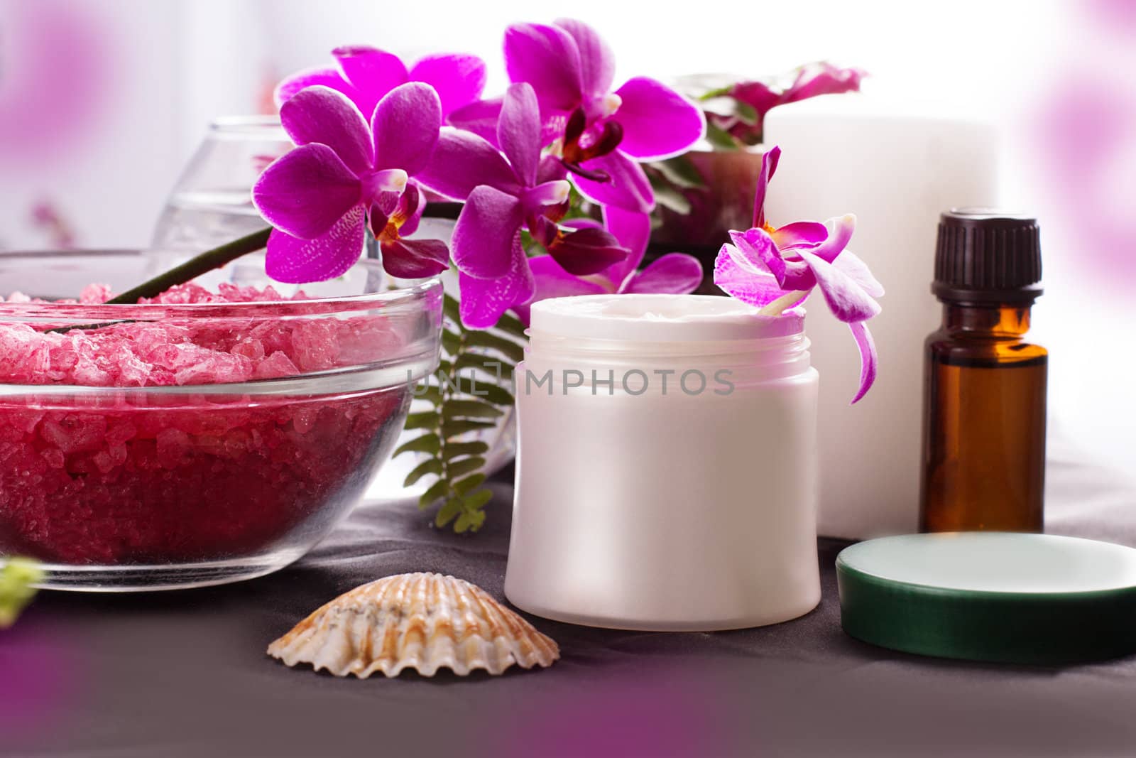 Beauty spa settings with orchids, oil and cream