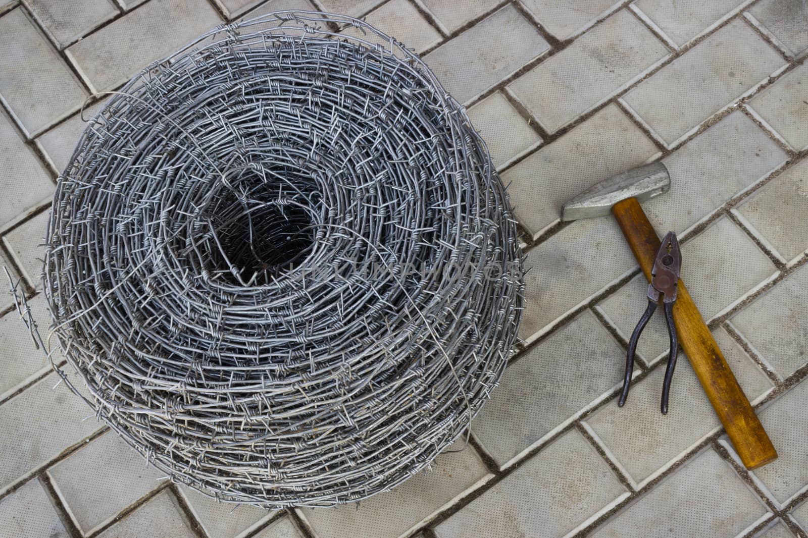 Bay of barbed wire and tool on the sidewalk