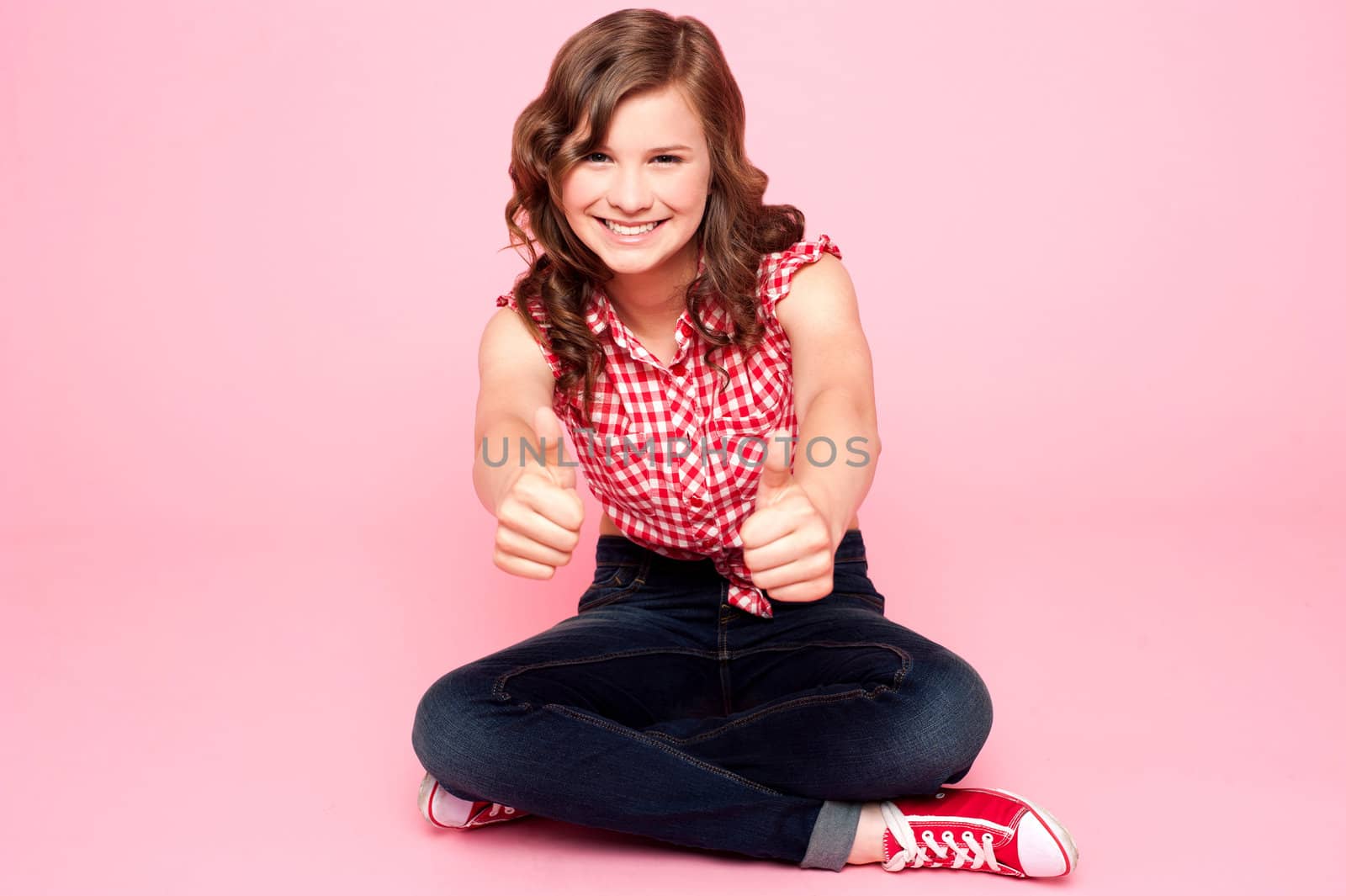 Pretty teenager showing double thumbs up to camera