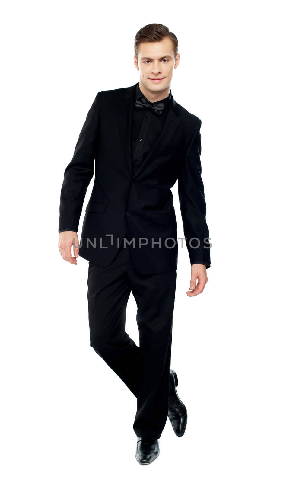 Isolated young man standing with crossed legs dressed in party wear