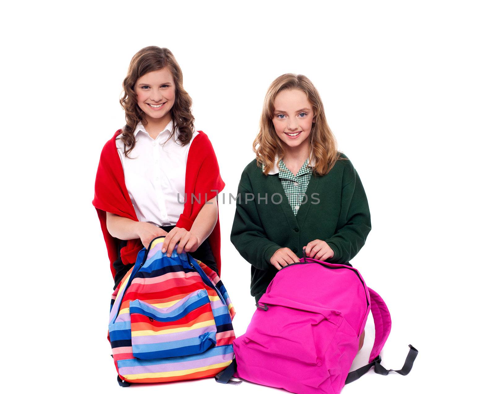 Pretty girls unzipping school bag and looking at camera. Smiling