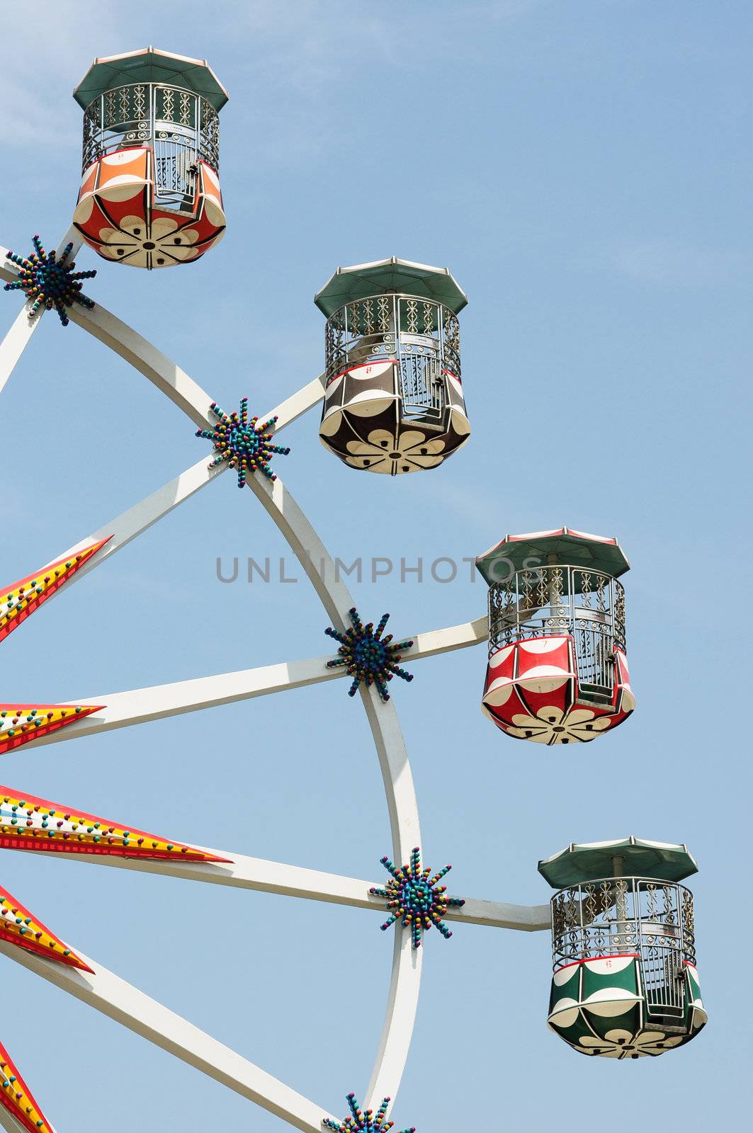 Bottom up view of Ferris wheel against blue sky in a park