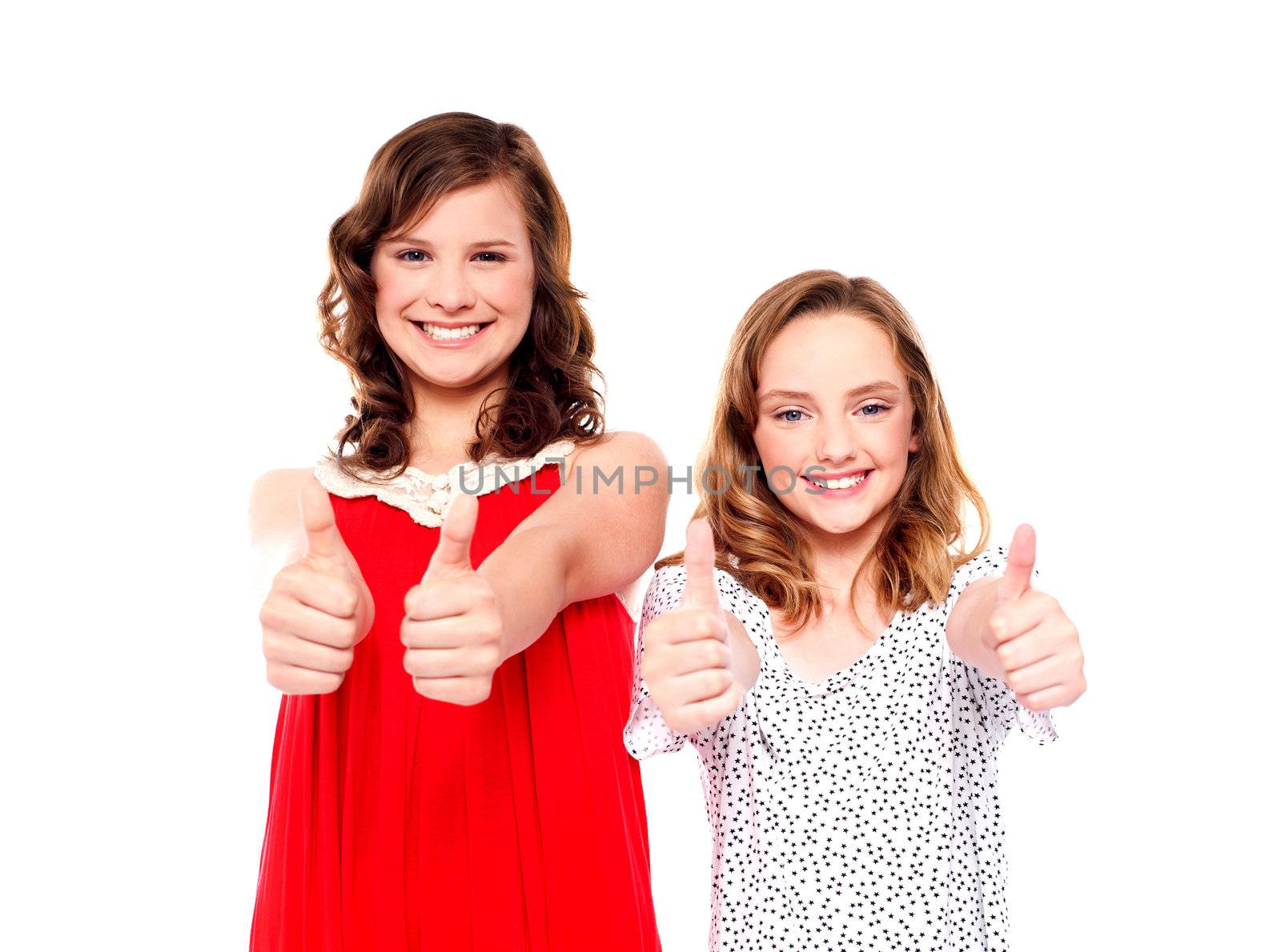 Two beautiful girls smiling and showing thumbs up at camera