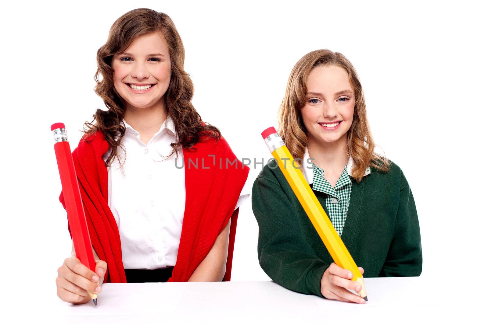 Isolated female students writing with big pencil on white surface