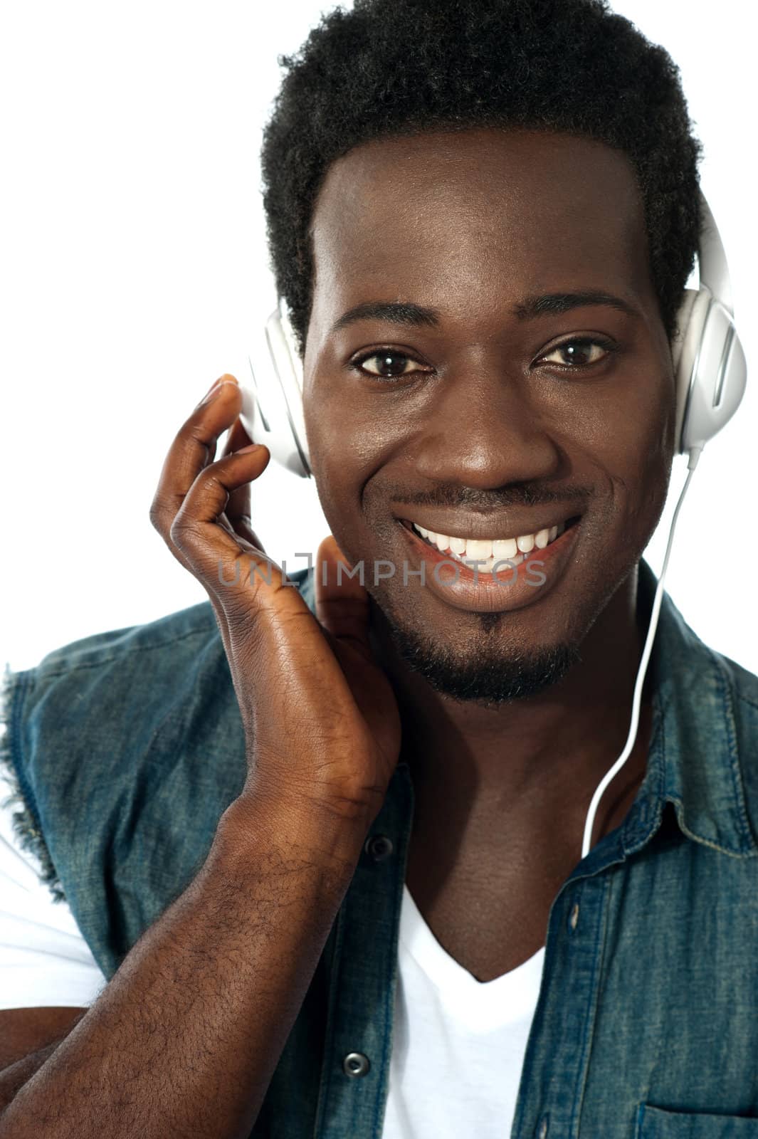 Young man listening to music through headphones, closeup shot