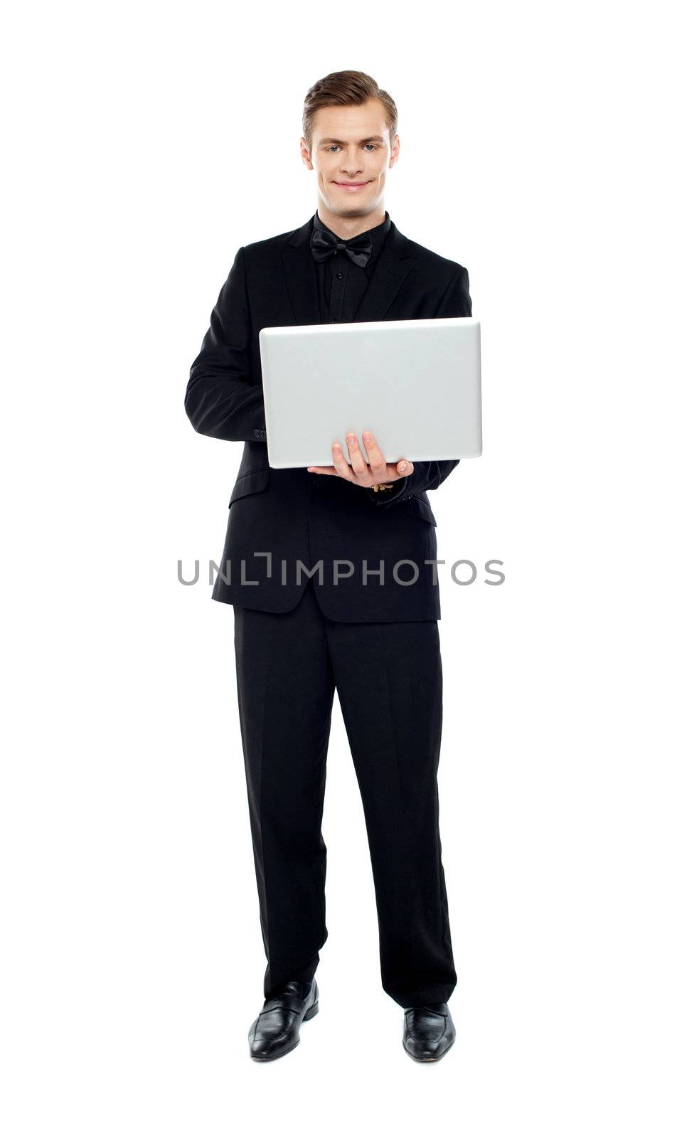 Smiling young man working on laptop against white background
