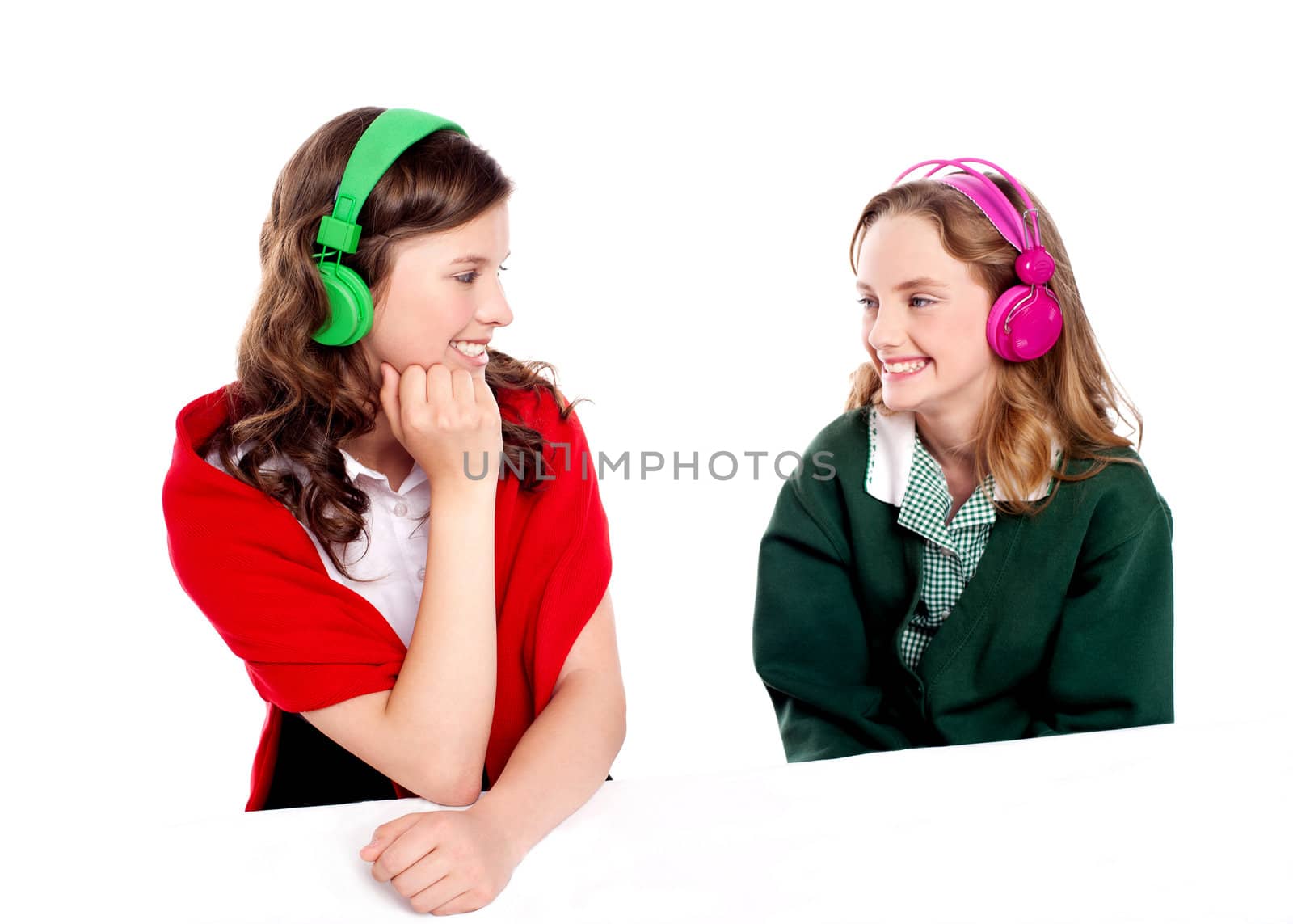 Pretty girls enjoying music. Looking at each other. All on white background