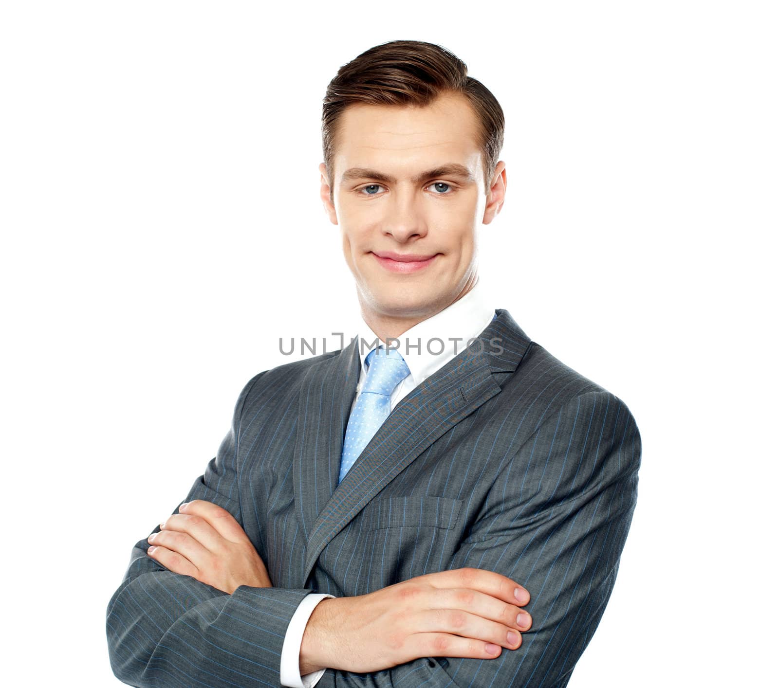 Portrait of handsome young businessman posing with crossed arms against white background