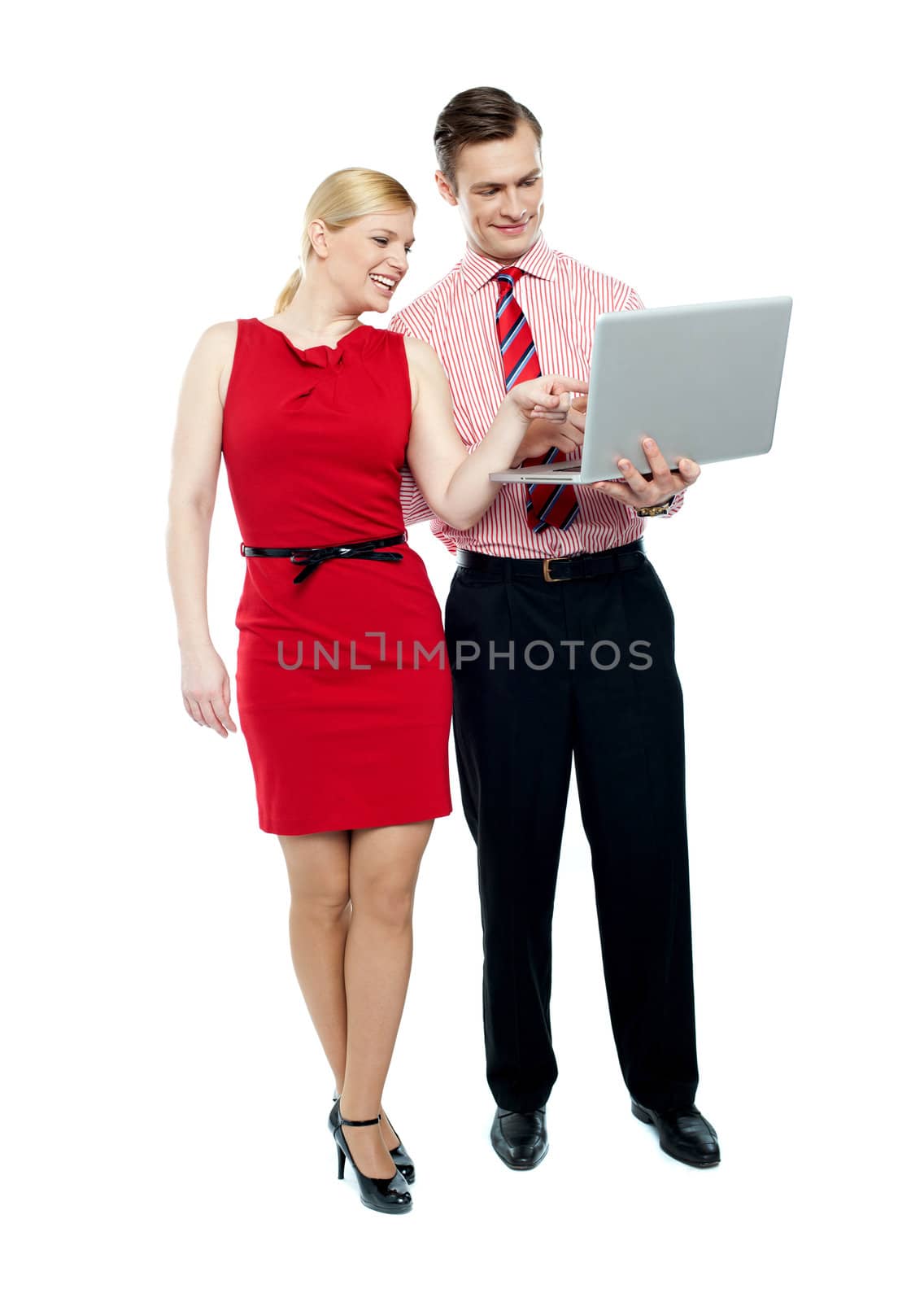 Female secretary pointing into laptop while boss operates. Full length shot