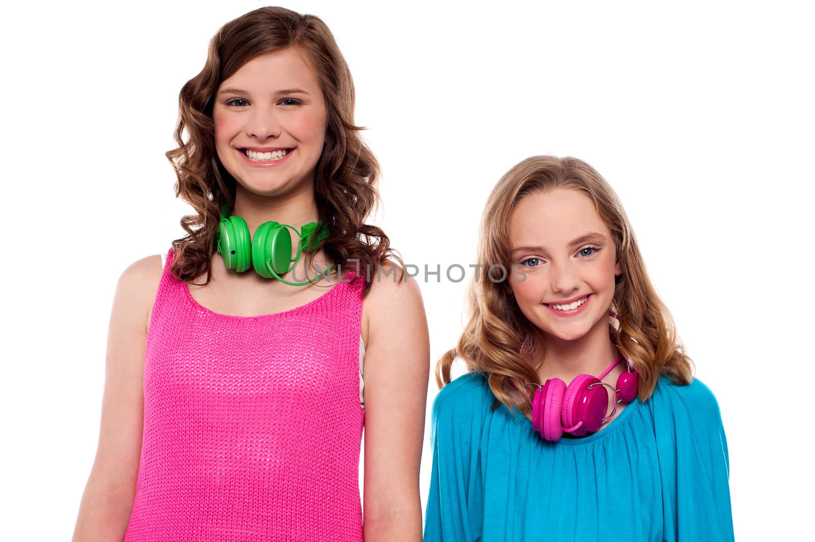 Teenagers posing with headphones around neck in front of camera