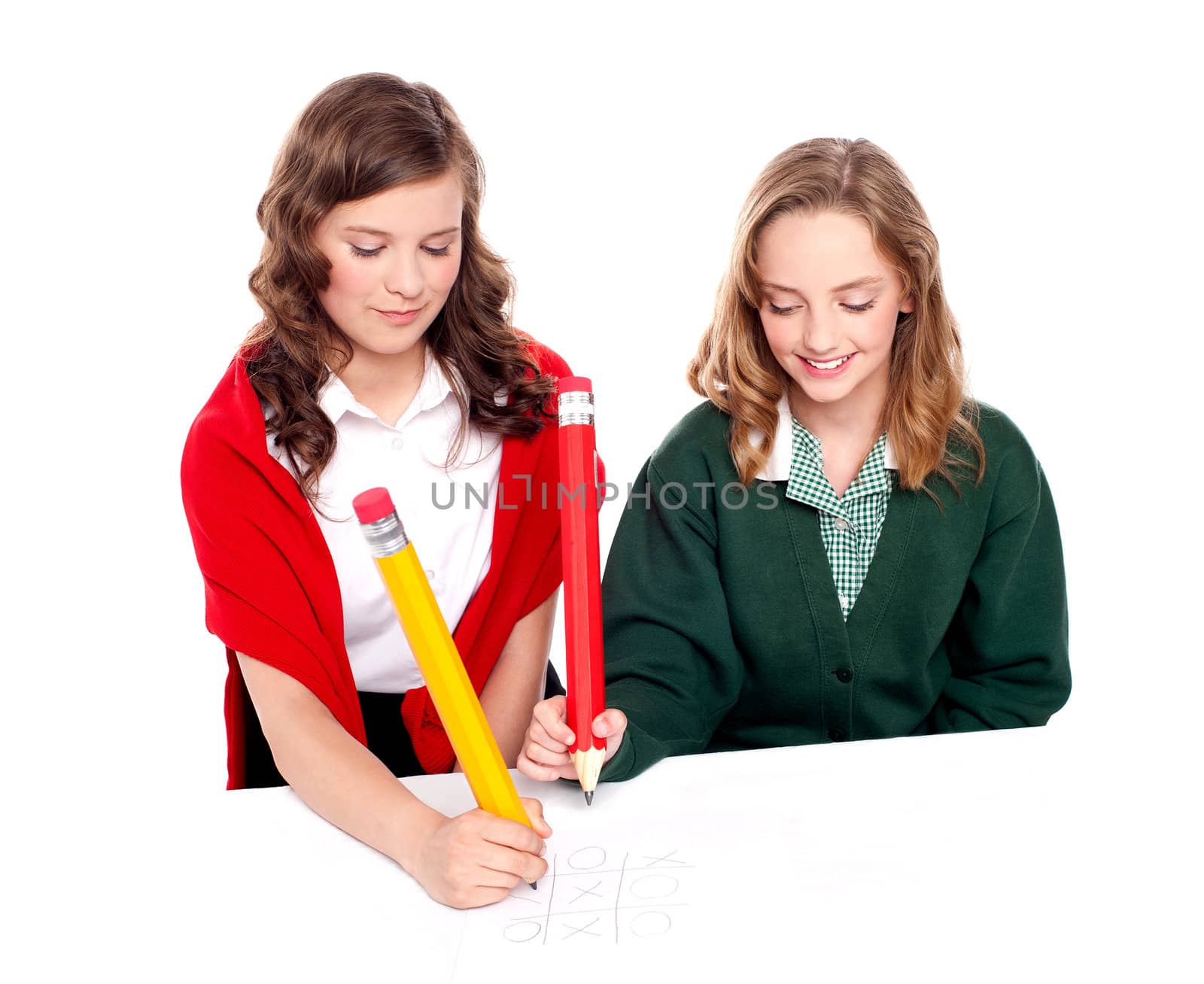 Teenager friends playing ouths and crosses with big pencil on white