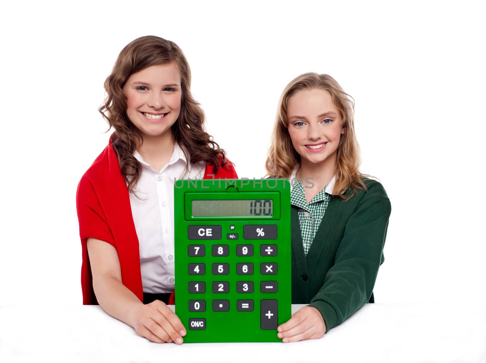 Girls showing big green calculator to camera against white background