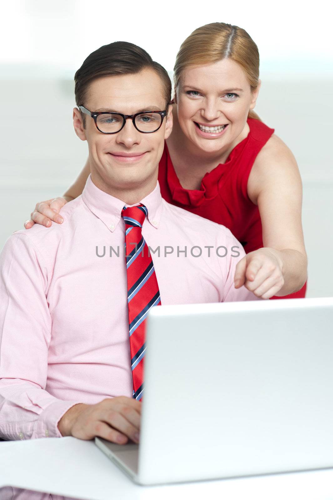 Corporate couple enjoying videos on laptop by stockyimages