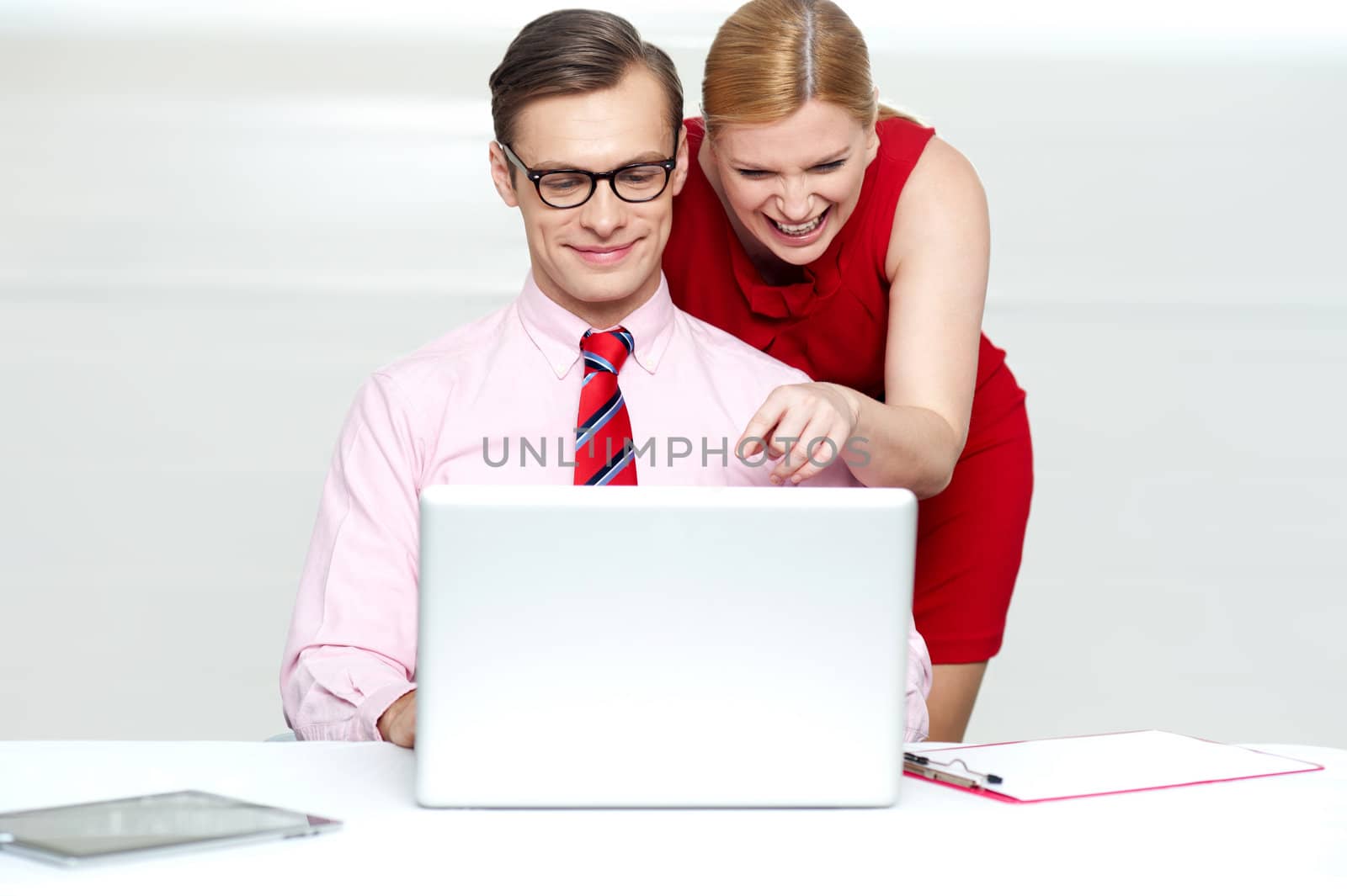 Lady pointing at something funny in laptop by stockyimages