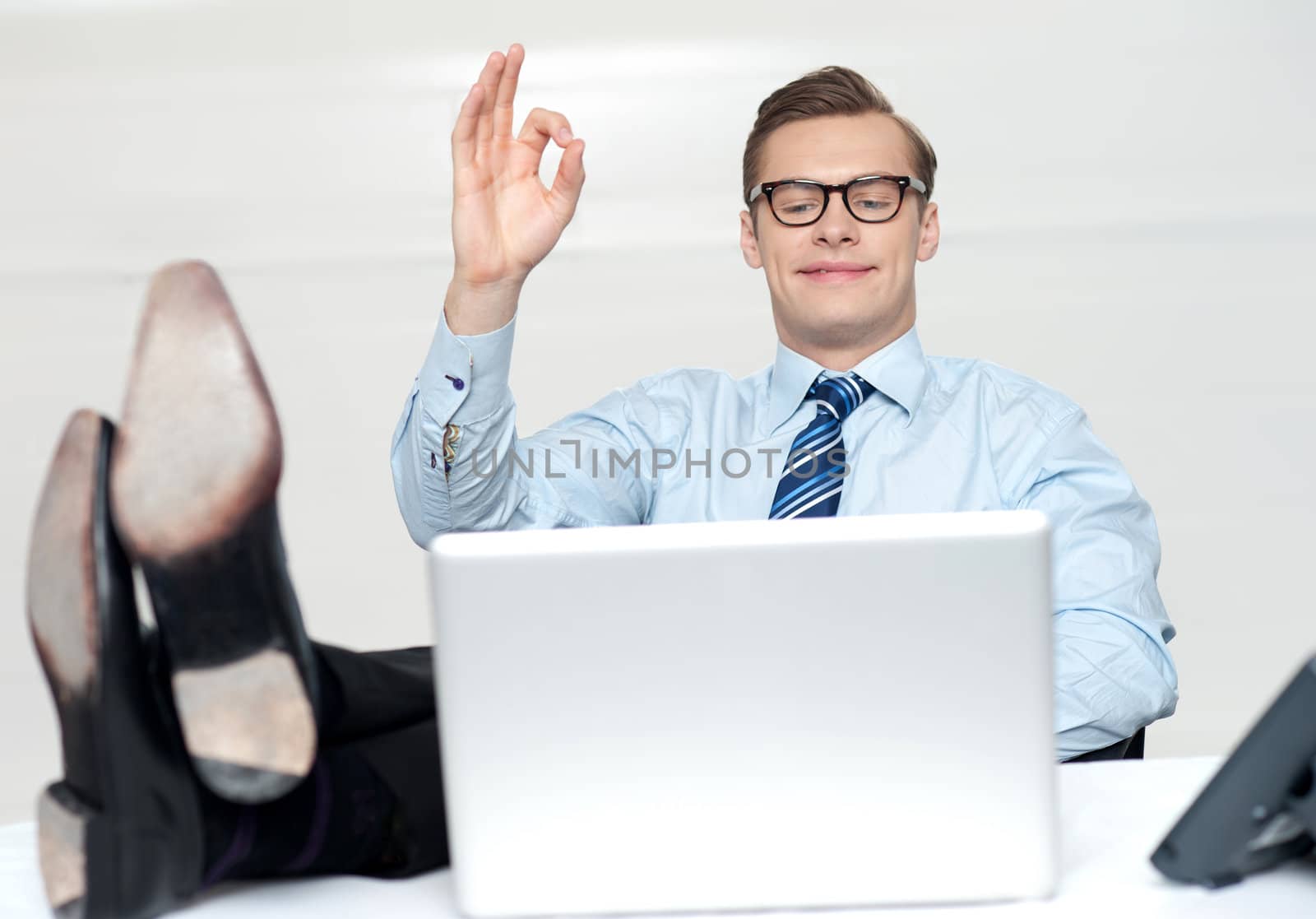 Relaxed man with excellent gesture looking at laptop