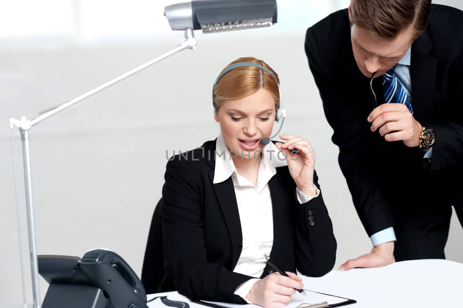 Woman discussing problem with male colleague by stockyimages