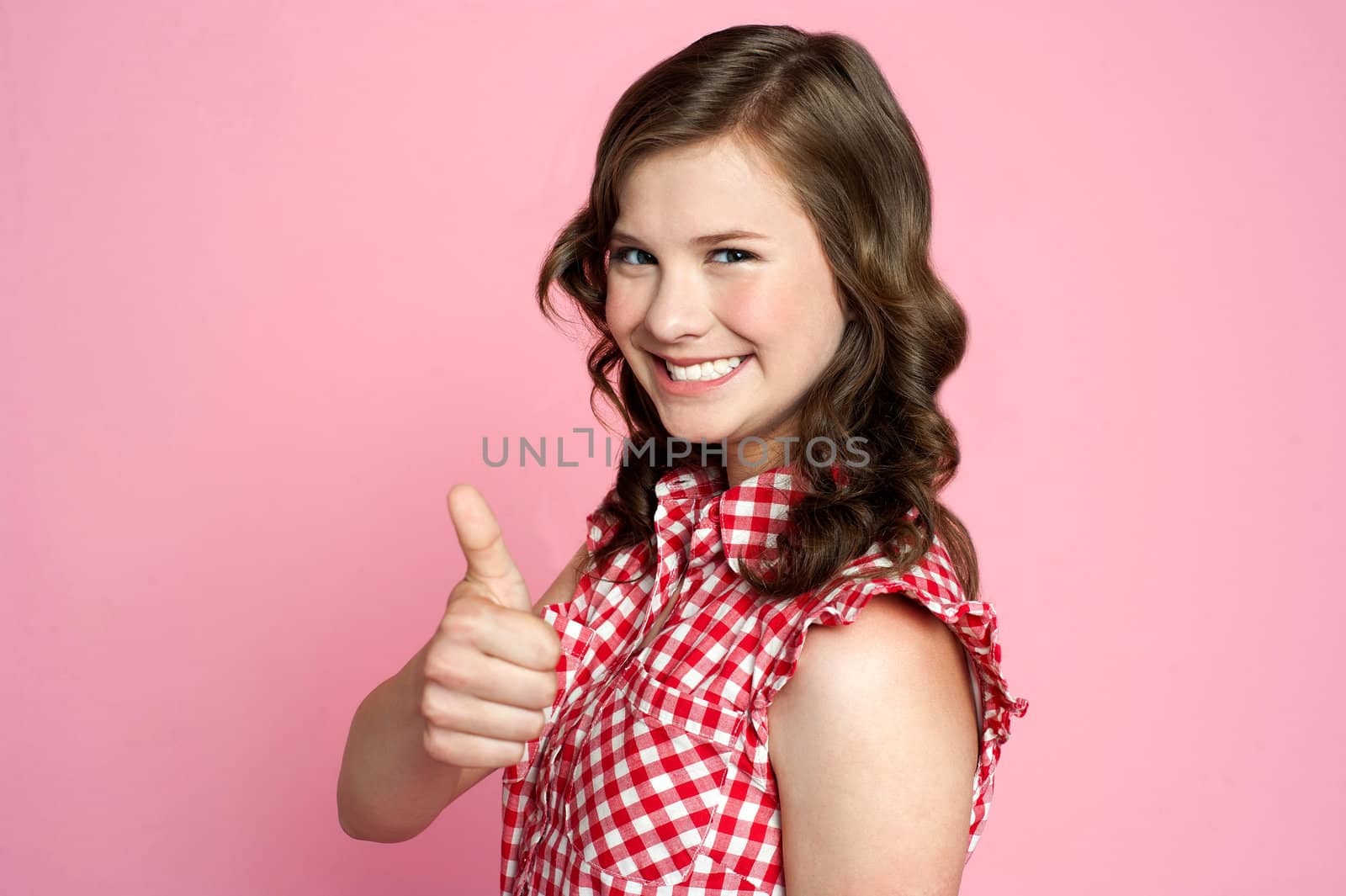 Beautiful smiling girl with ok gesture,side view