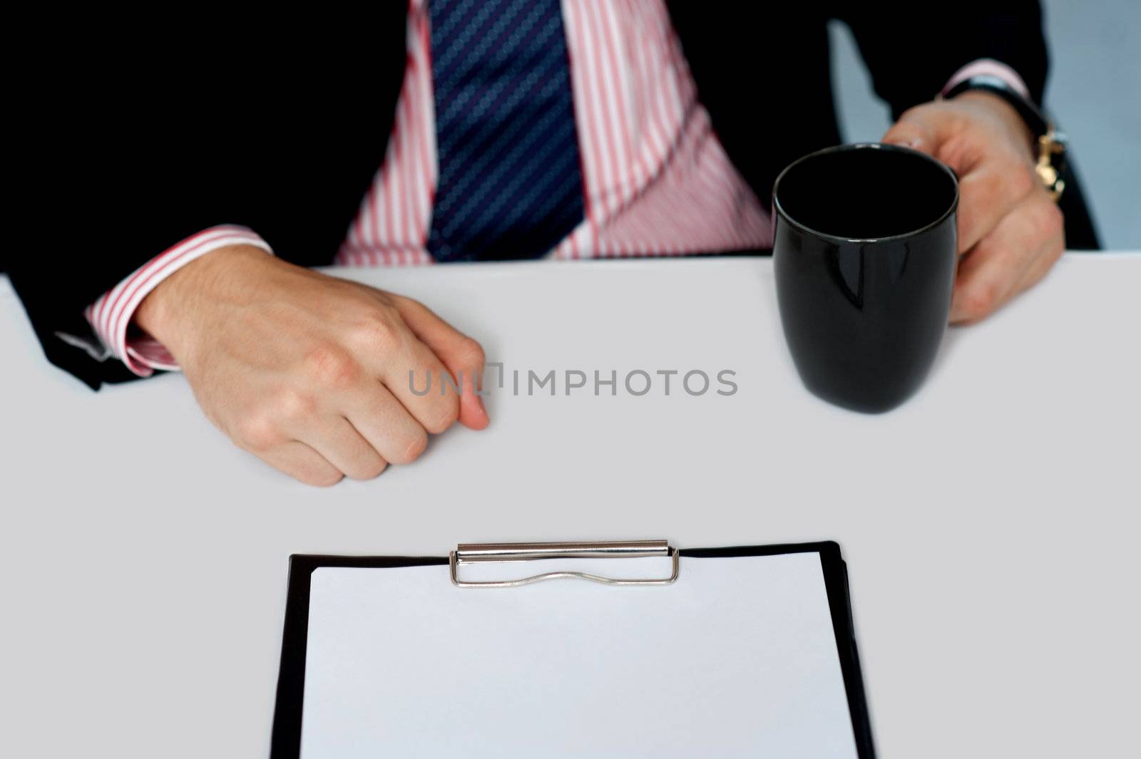 Closeup of businessman holding empty cup. Office desk. Closeup shot