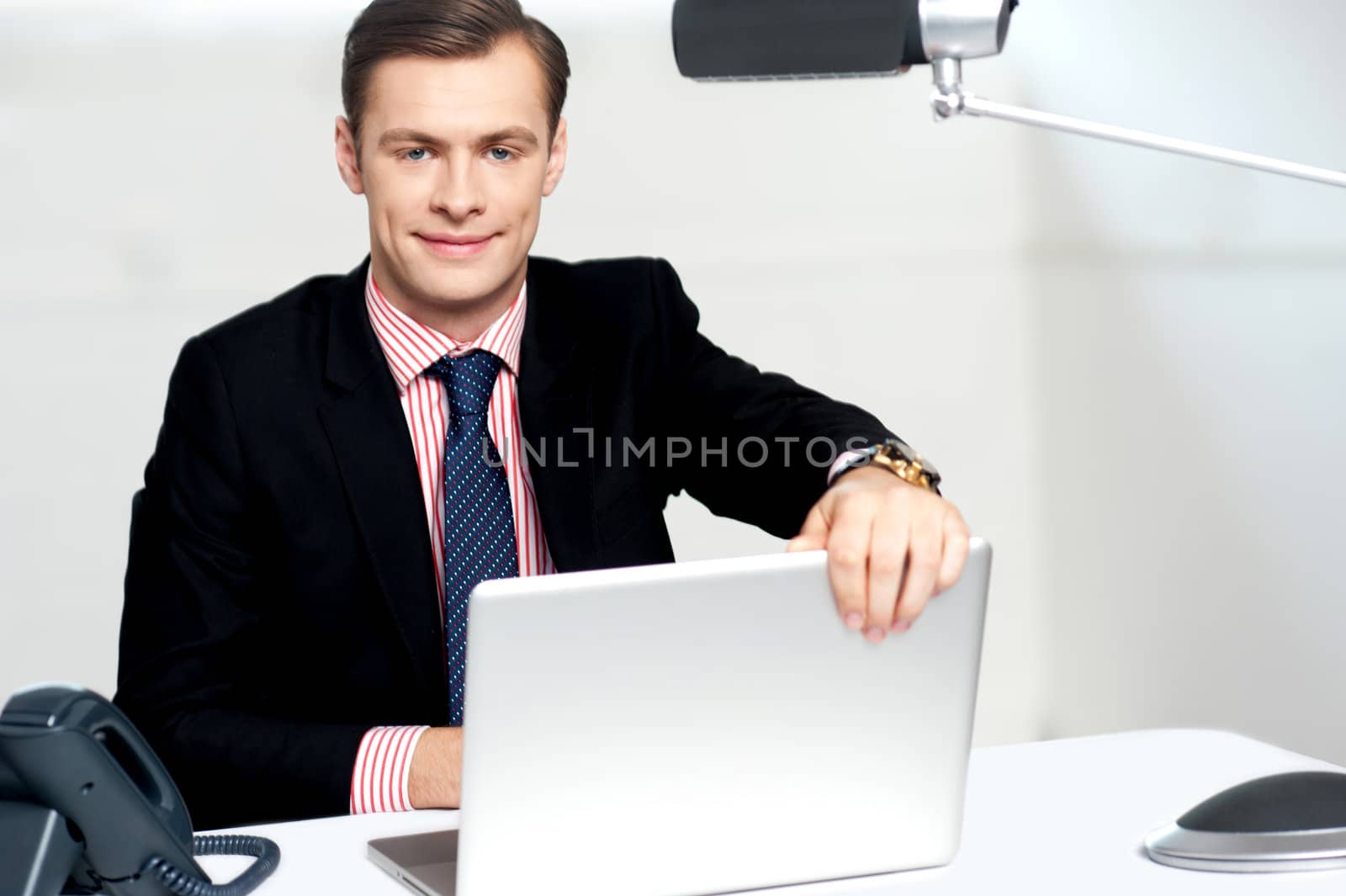 Young happy businessman holding laptop about to shut it down. Lets call it a day