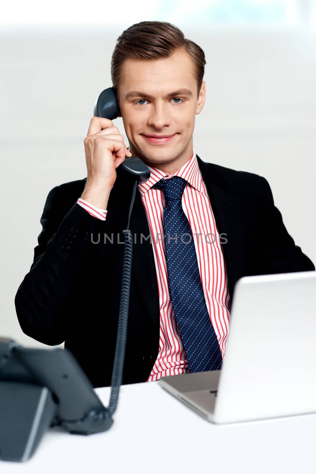 Male executive on a business call with client. Sitting in office