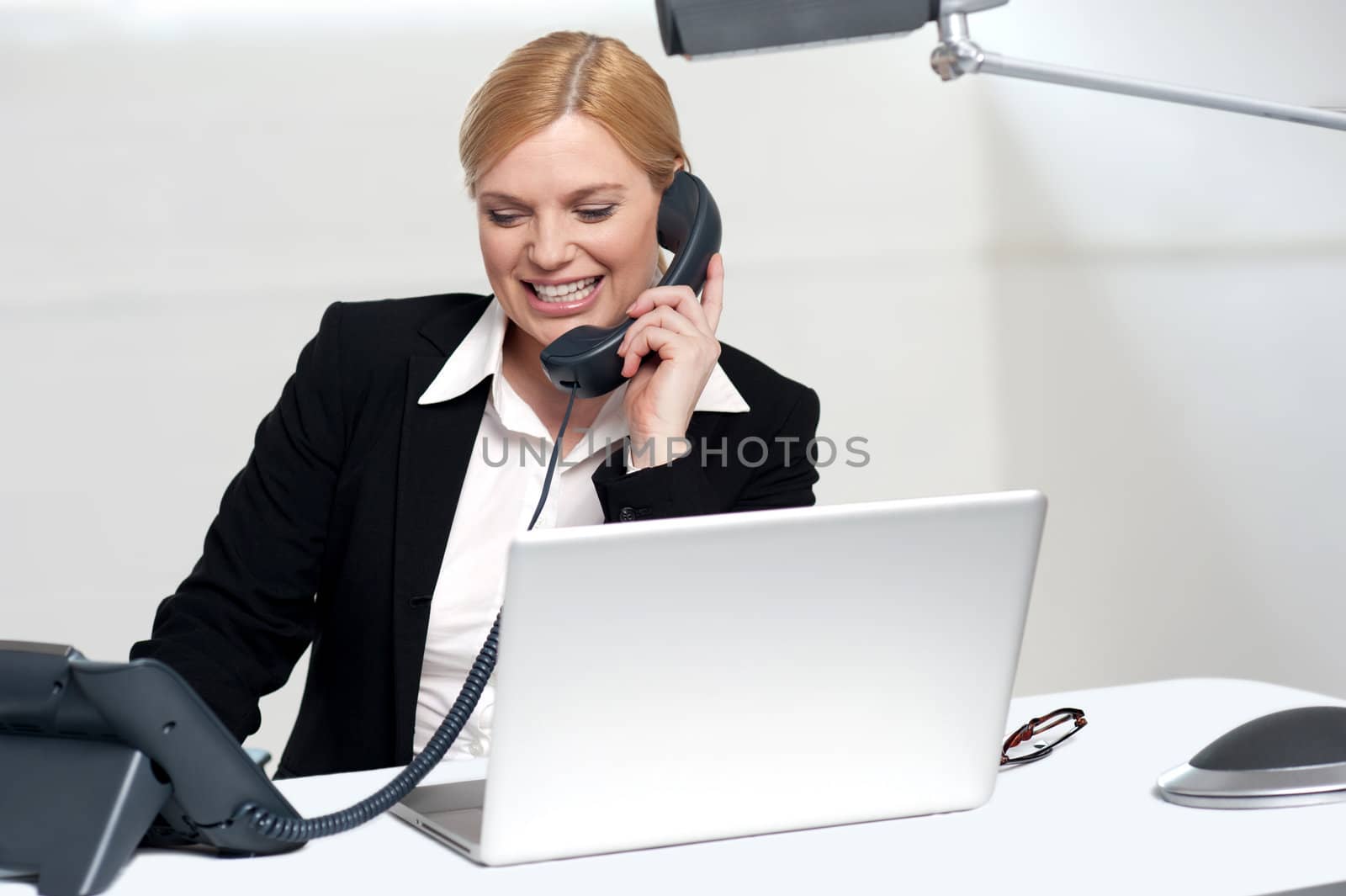 Female secretary communicating with her boss on phone in the office