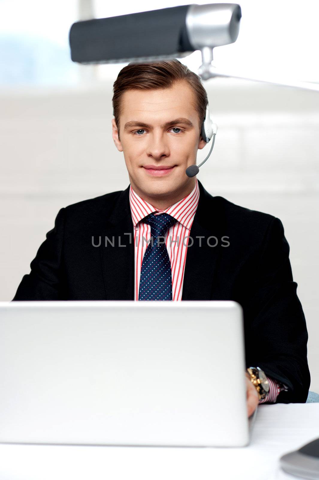 Portrait of handsome male operator wearing headset looking at camera
