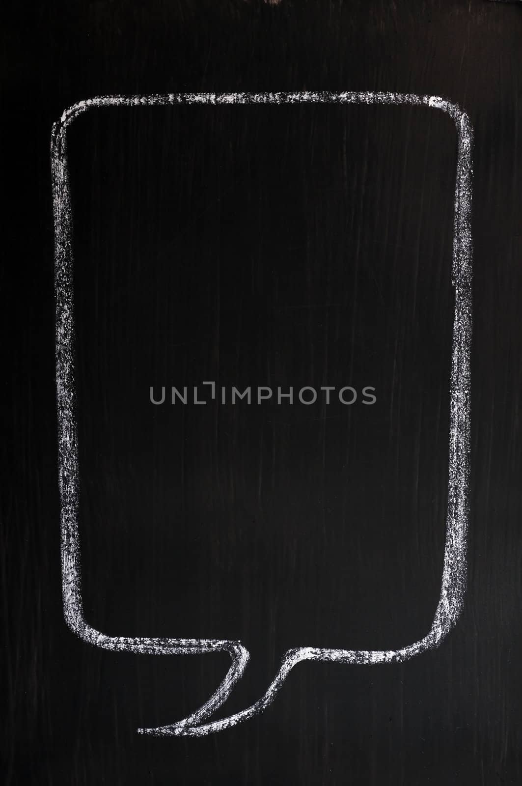 Blank speech bubble drawn with chalk on a smudged blackboard background for text writing and design
