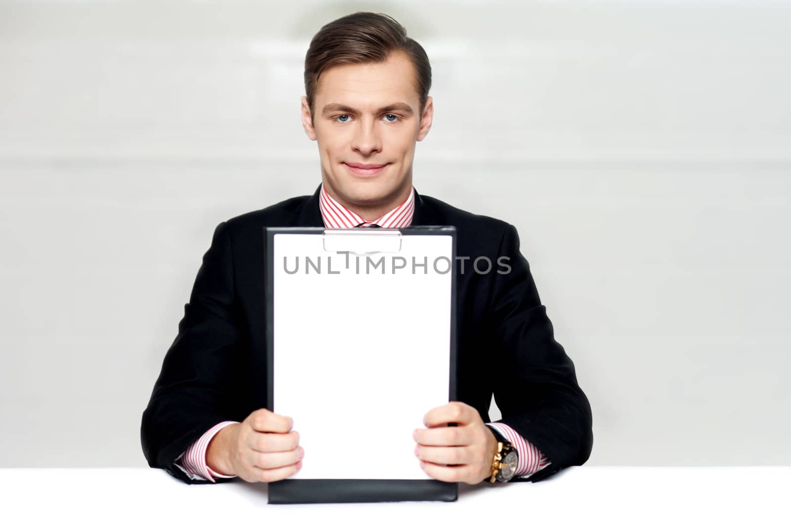 Corporate man showing blank clipboard isolated over gray background