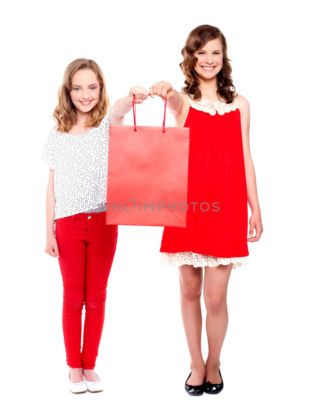 Full length portrait of beautiful teenagers holding shopping bag