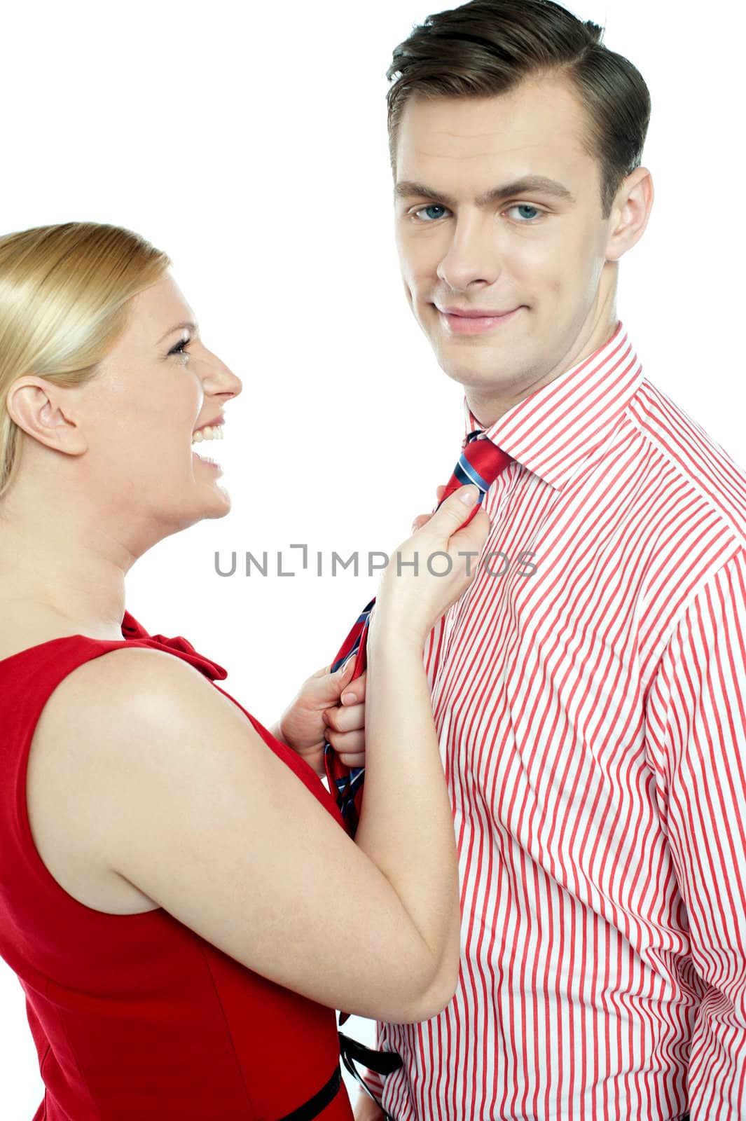 Glamorous woman pulling man by his tie isolated over white