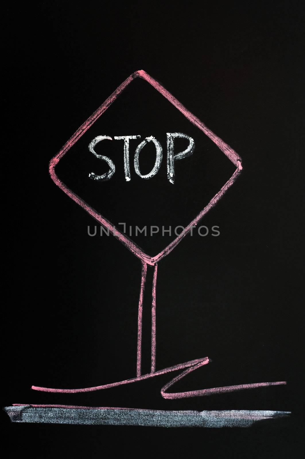 Stop warning sign drawn with red chalk on a blackboard background