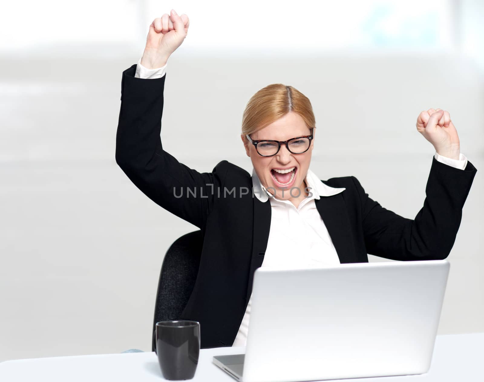 Caucasian corporate woman enjoying success with both hands raised up