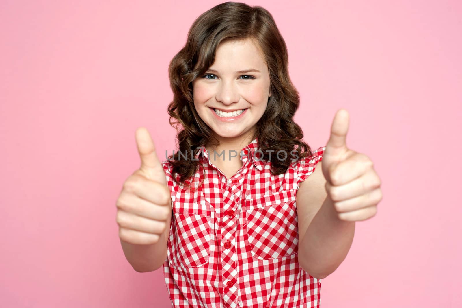 Gorgeous girl showing double thumbs up against pink background