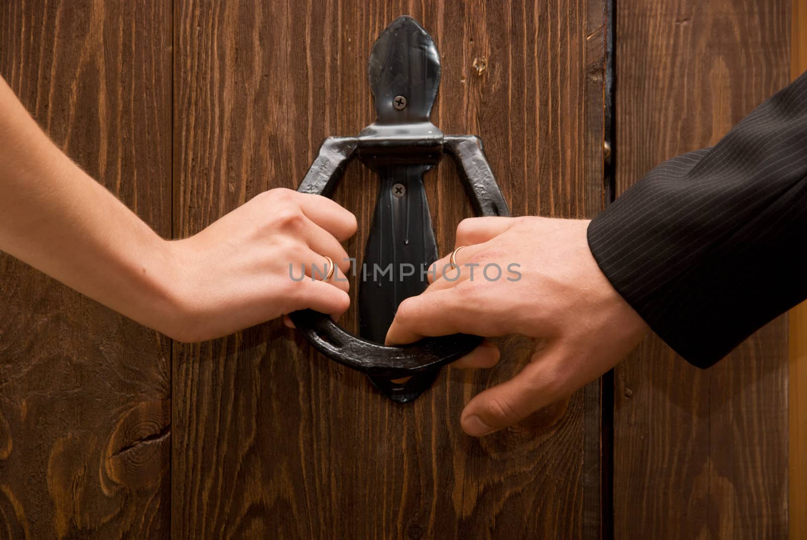 Close up of just married hands opening the door together