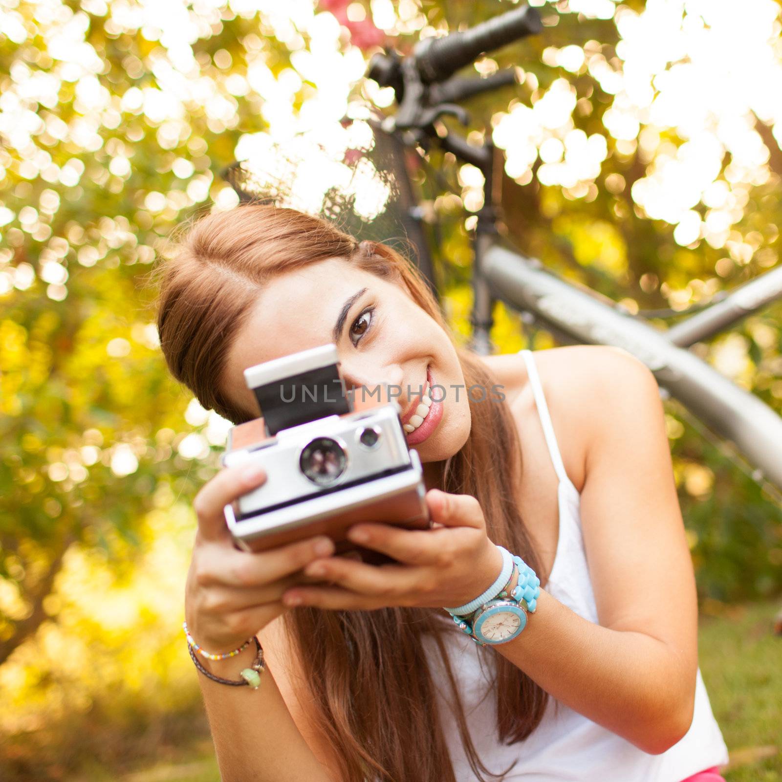 beautiful young woman playing with a vintage camera