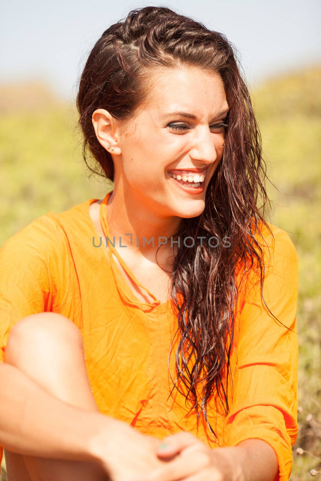 Portrait of young beautiful woman laughing wearing orange shirt by Lcrespi