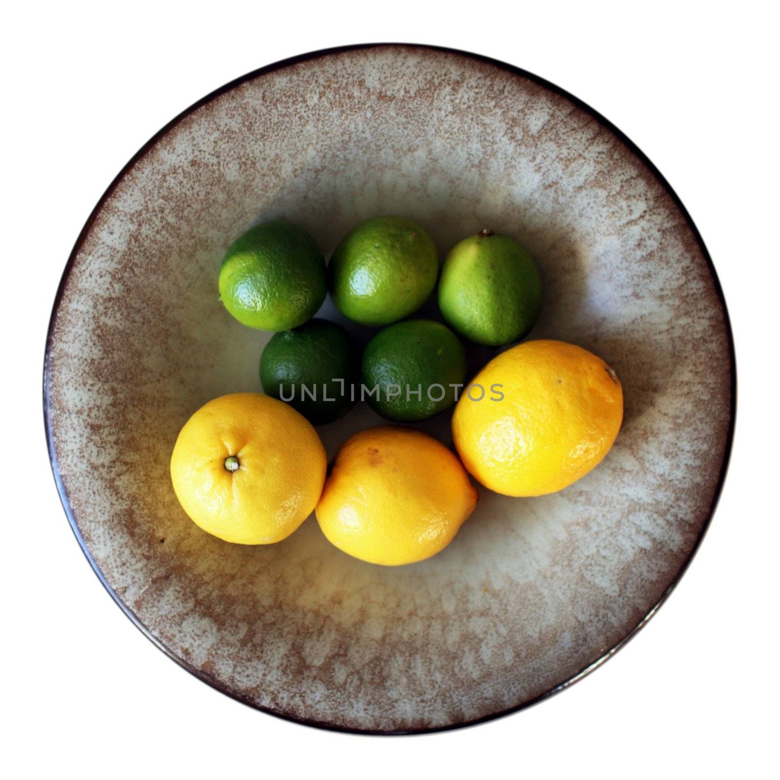 Five limes and three lemons in a clay bowl