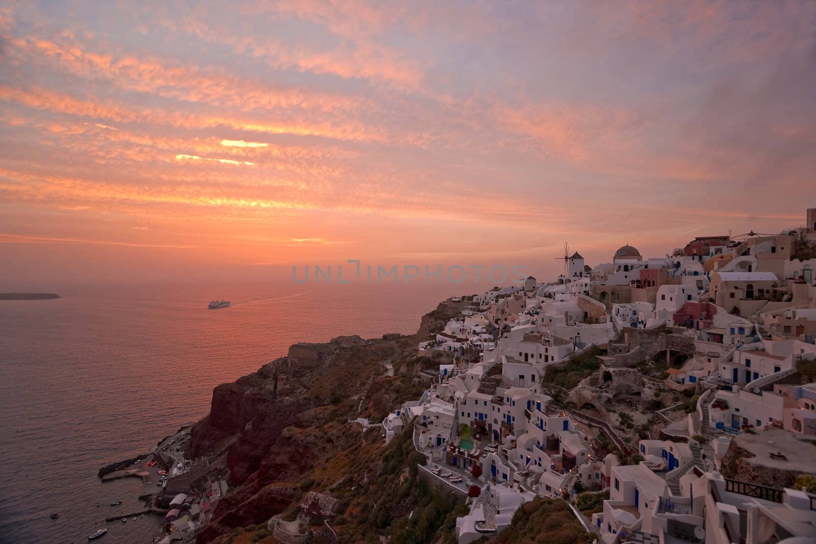 Santorini sunset in Ia village with the ship coming to the island