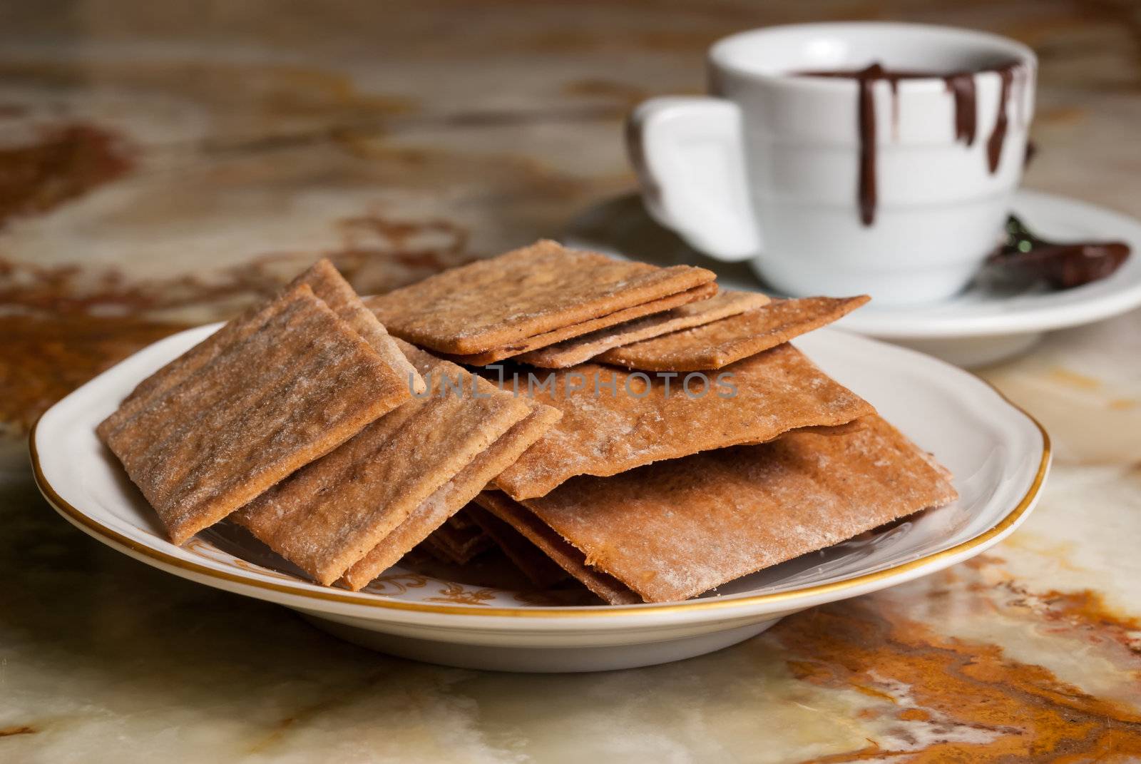 Plate full of cookies and coffe cup with chocolate flowing