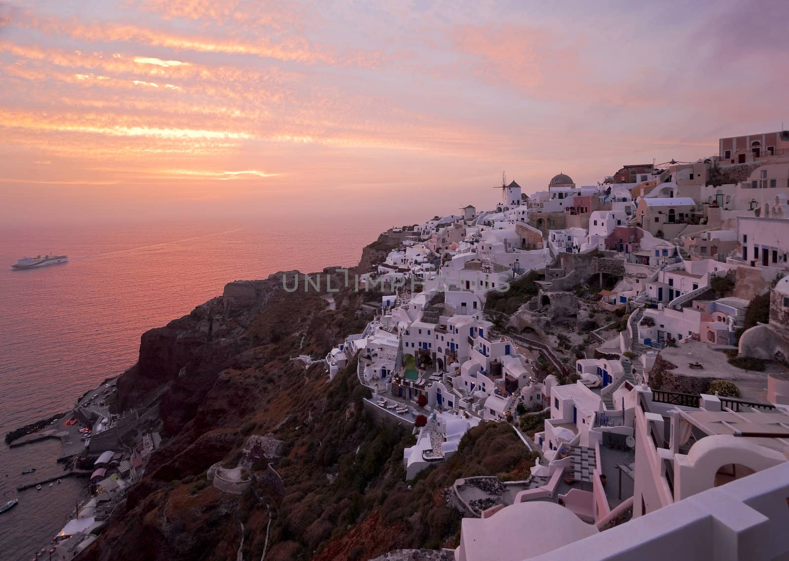 Santorini sunset in Ia village with the ship coming to the island