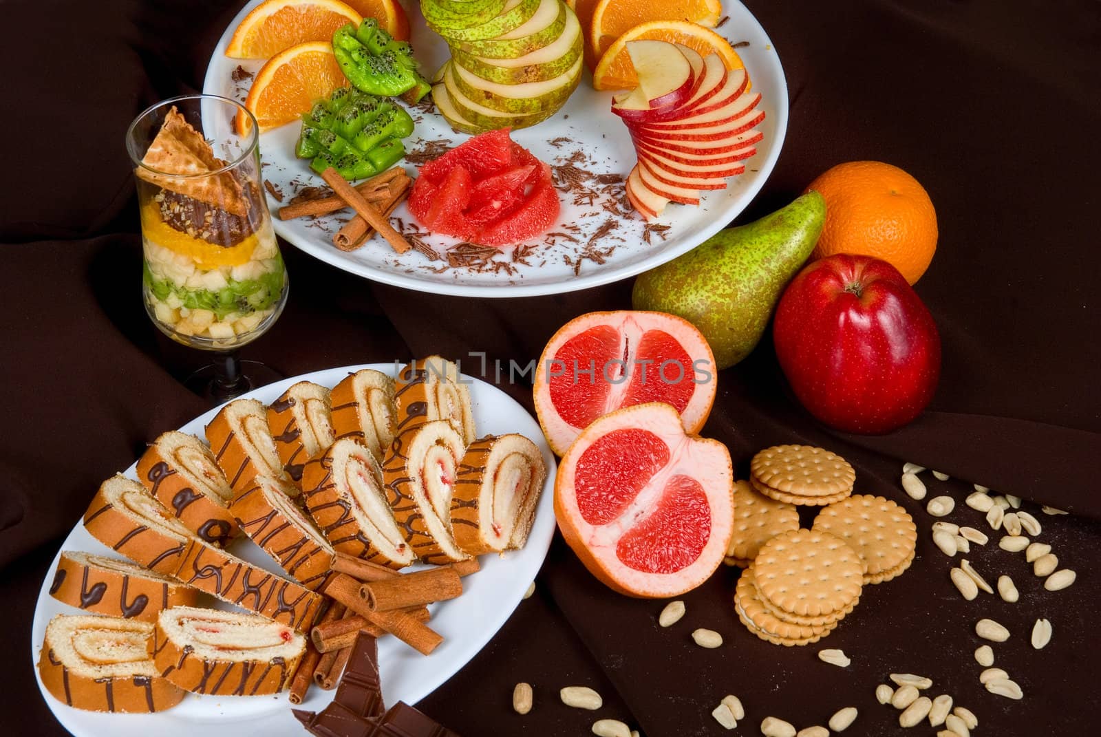 Set of sweet fruit and cake on a dark background