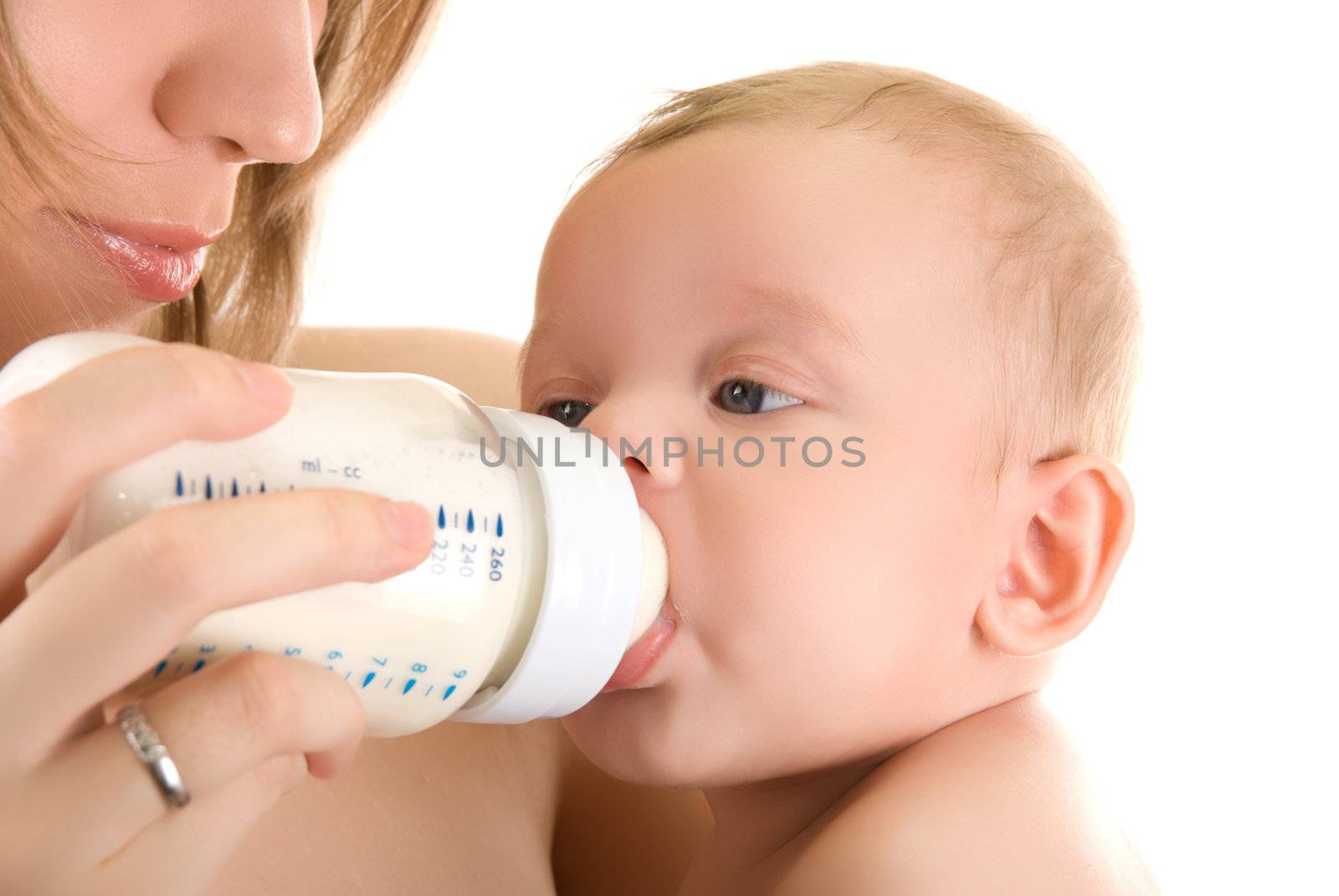 Mother give drink her baby boy by feeding bottle over white