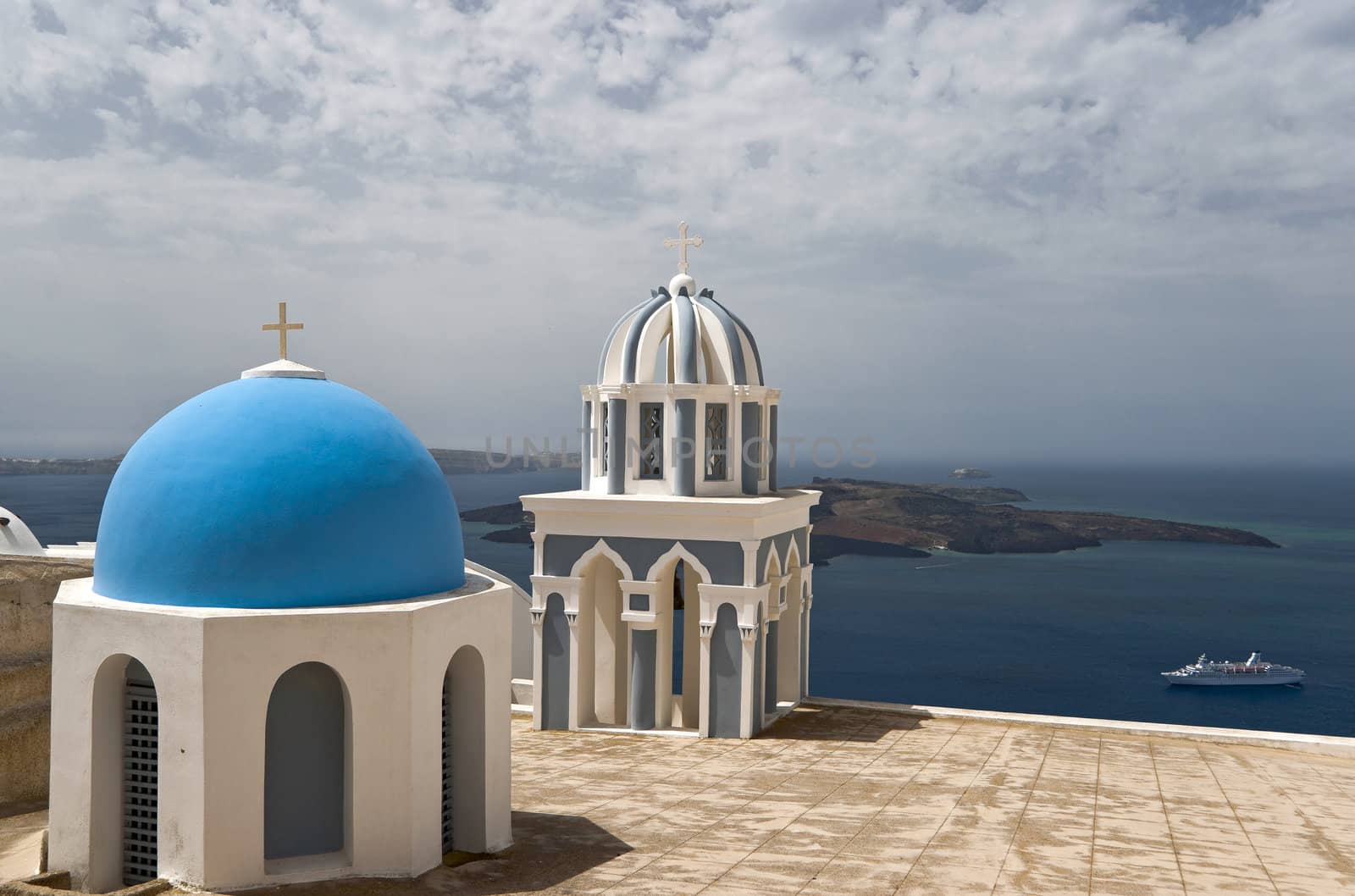 Caldera view in Santorini island with cupolas of churches and ships