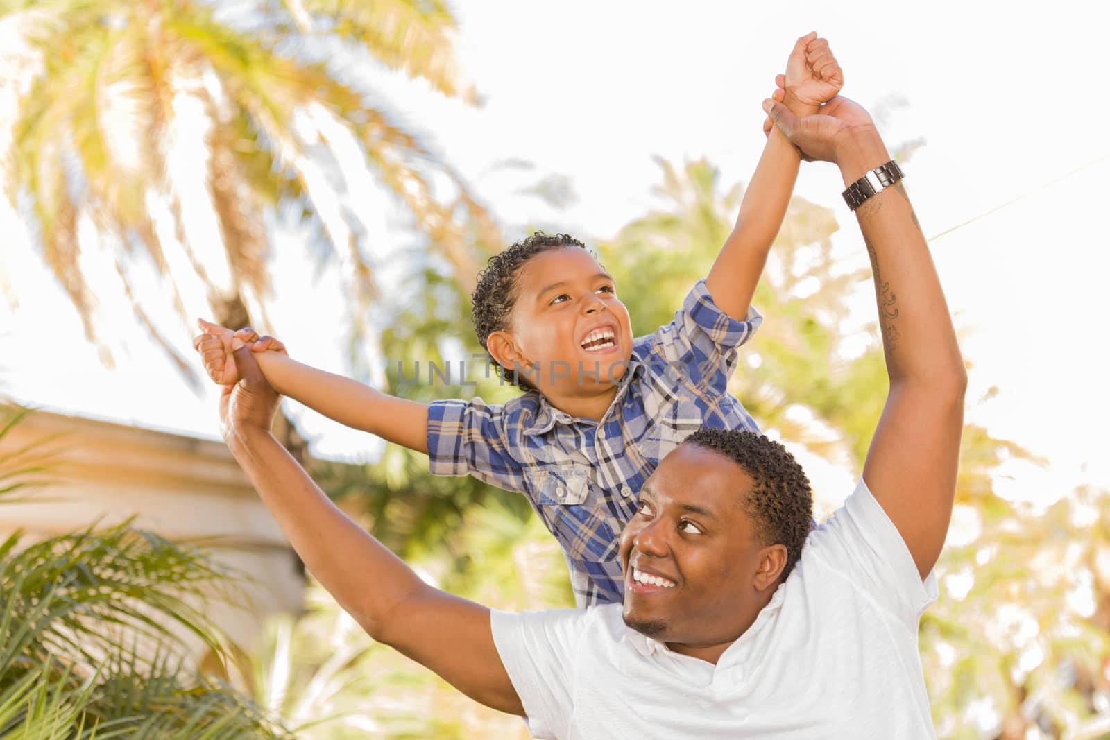 Mixed Race Father and Son Playing Piggyback by Feverpitched