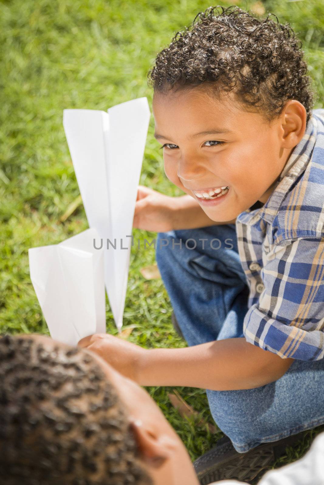 Mixed Race Father and Son Playing with Paper Airplanes by Feverpitched