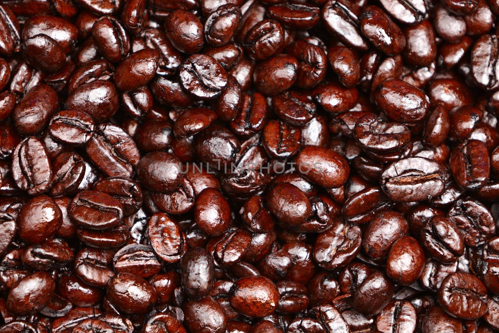 Coffee beans background texture. Dark roast arabica coffee beans heap close-up.