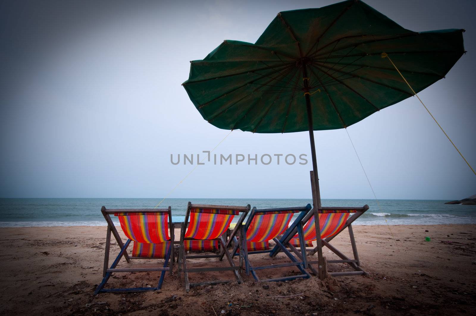 four Beach chairs with umbrella on Hua Hin beach Thailand